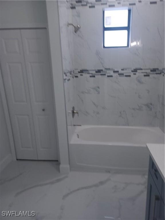 bathroom featuring tiled shower / bath combo and vanity