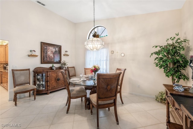 dining space with a high ceiling and light tile patterned floors