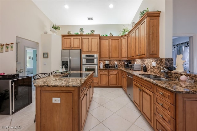 kitchen featuring sink, tasteful backsplash, dark stone countertops, stainless steel appliances, and beverage cooler