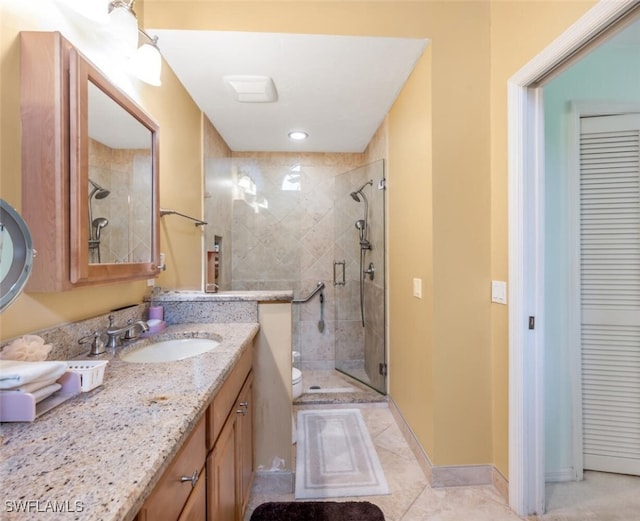 bathroom with tile patterned floors, vanity, toilet, and an enclosed shower