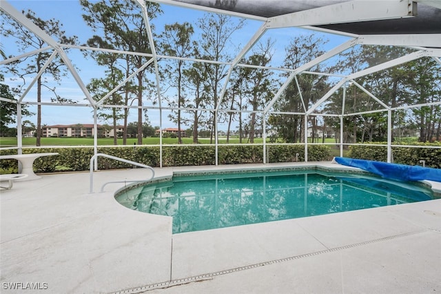 view of swimming pool with a patio and glass enclosure