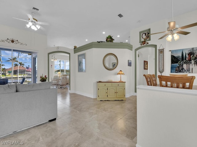 living room with ceiling fan with notable chandelier