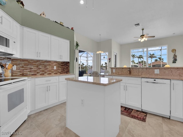 kitchen featuring ceiling fan, white cabinets, hanging light fixtures, and white appliances