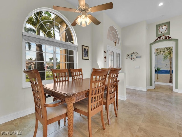 dining area with ceiling fan, french doors, and a high ceiling