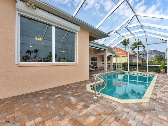 view of pool featuring a patio area and glass enclosure