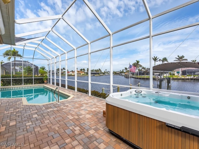 view of pool with a hot tub, a water view, glass enclosure, and a patio area