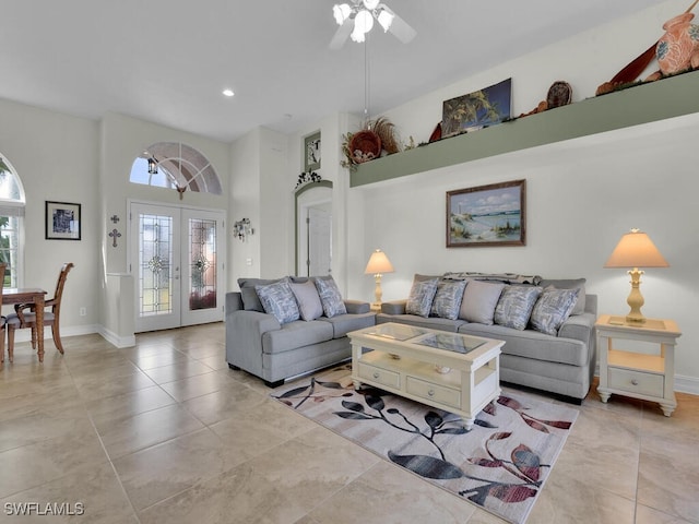 living room featuring ceiling fan, a towering ceiling, and french doors