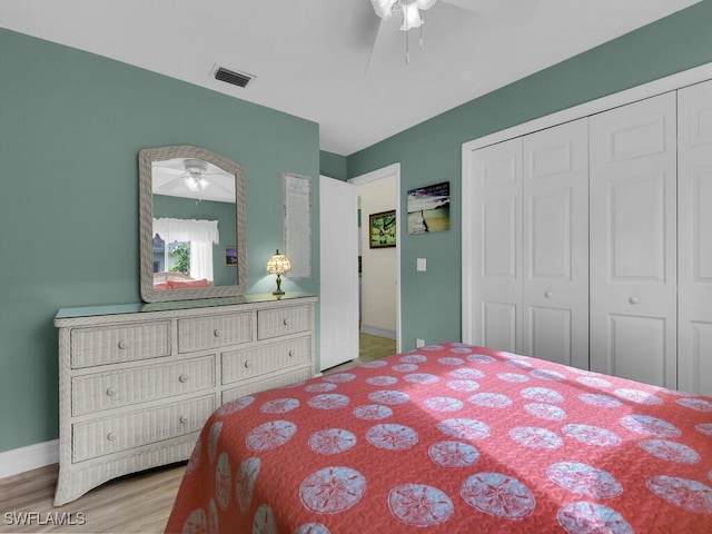 bedroom with a closet, light hardwood / wood-style floors, and ceiling fan