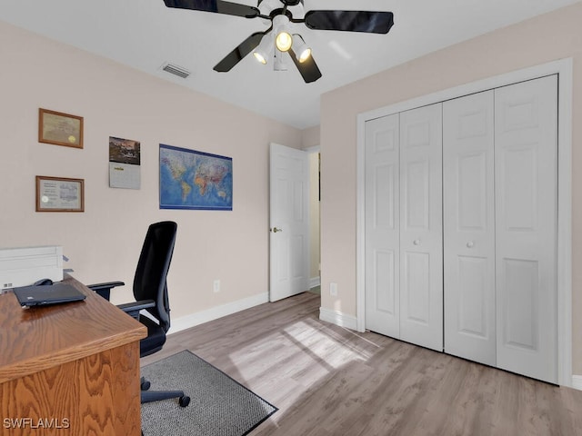 office with light hardwood / wood-style floors and ceiling fan