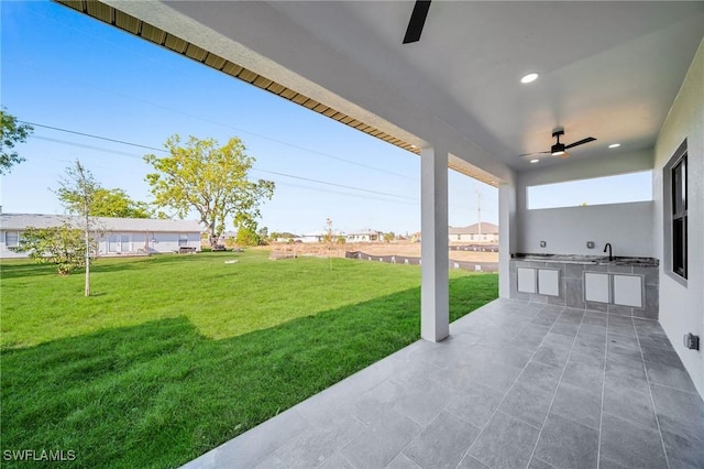 view of yard featuring a patio area, sink, and exterior kitchen