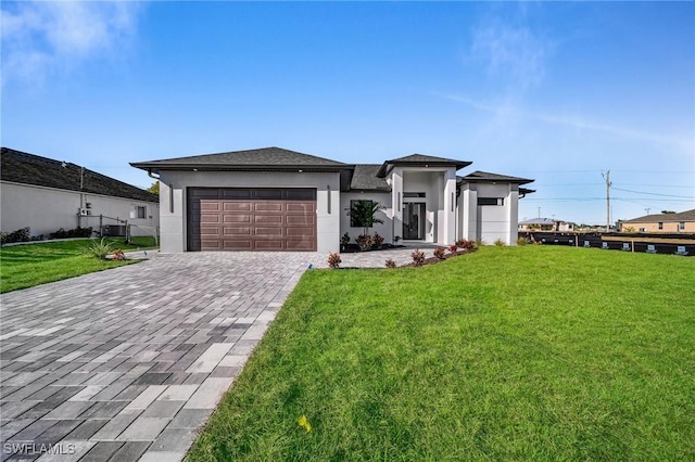 prairie-style house with a garage and a front lawn