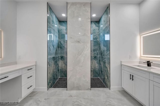 bathroom with a tile shower and vanity