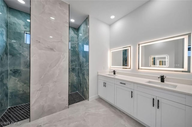 bathroom featuring a tile shower and vanity