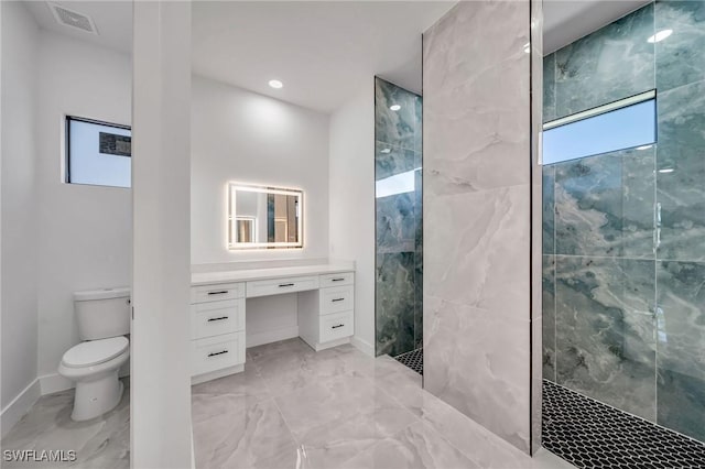 bathroom featuring tiled shower, vanity, and toilet