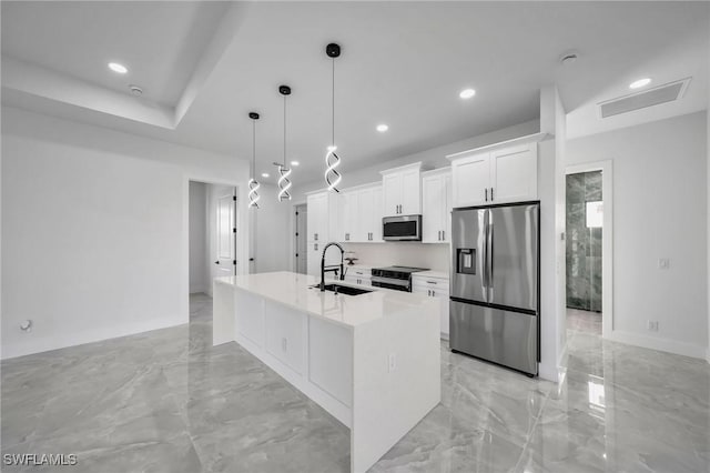 kitchen featuring white cabinets, sink, hanging light fixtures, an island with sink, and stainless steel appliances