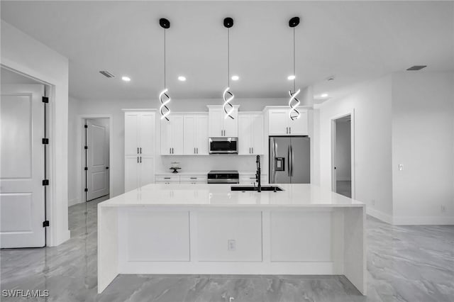 kitchen featuring white cabinets, appliances with stainless steel finishes, decorative light fixtures, and a kitchen island with sink