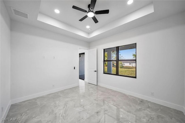 unfurnished room featuring a tray ceiling and ceiling fan