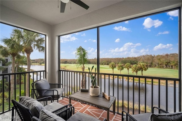 sunroom / solarium with ceiling fan and a water view