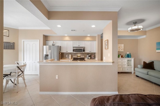 kitchen featuring kitchen peninsula, stainless steel appliances, crown molding, light tile patterned floors, and white cabinetry