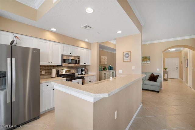 kitchen featuring white cabinets, stainless steel appliances, crown molding, and light tile patterned flooring