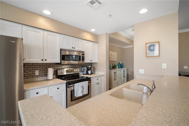 kitchen featuring sink, stainless steel appliances, tasteful backsplash, white cabinets, and ornamental molding