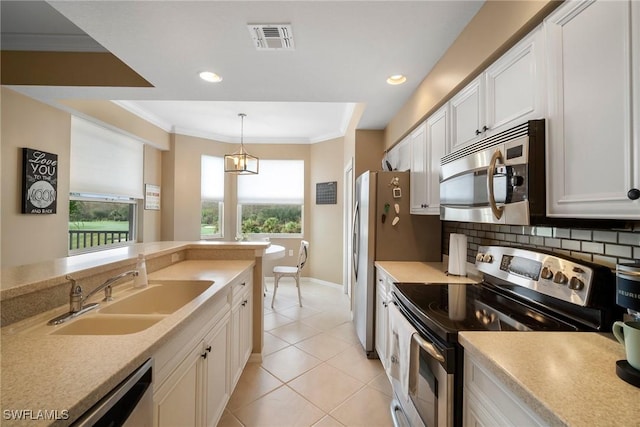 kitchen with sink, white cabinets, stainless steel appliances, and decorative light fixtures