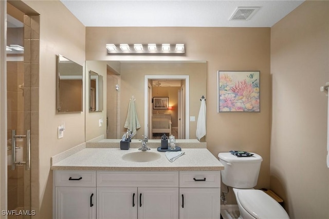 bathroom featuring vanity, toilet, and a shower with shower door