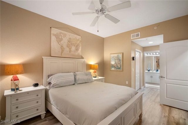 bedroom with connected bathroom, hardwood / wood-style flooring, and ceiling fan