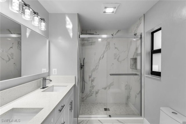 bathroom with toilet, an enclosed shower, and vanity