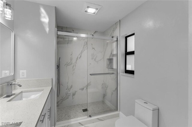 bathroom featuring toilet, vanity, and walk in shower