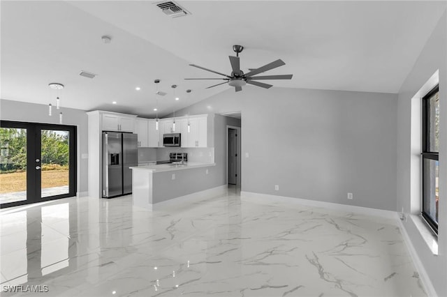 kitchen with lofted ceiling, french doors, white cabinets, decorative light fixtures, and stainless steel appliances