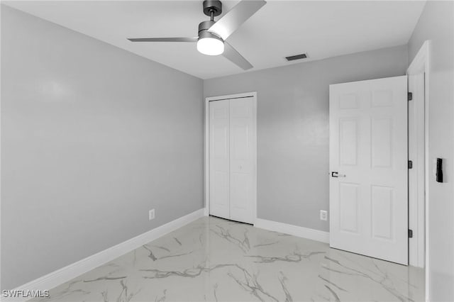 unfurnished bedroom featuring ceiling fan and a closet