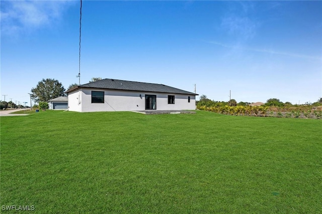 rear view of house featuring a yard and a patio