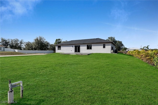 rear view of property with a lawn