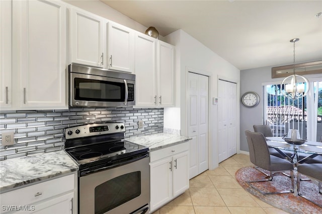 kitchen featuring a chandelier, stainless steel appliances, white cabinetry, and light tile patterned flooring