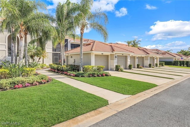 mediterranean / spanish-style house featuring a garage and a front yard