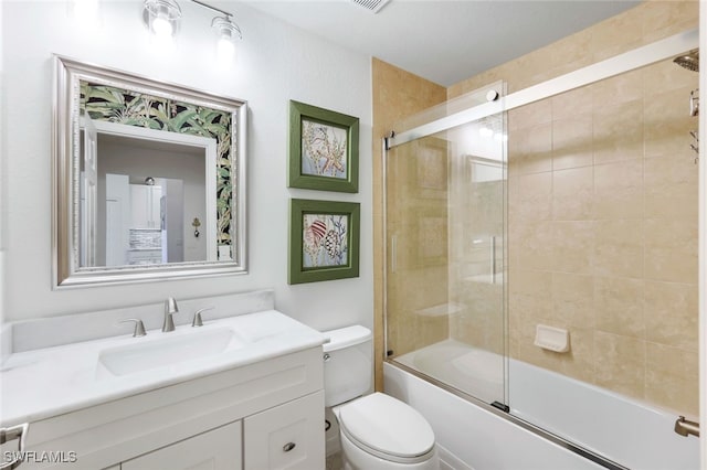 full bathroom featuring vanity, enclosed tub / shower combo, and toilet