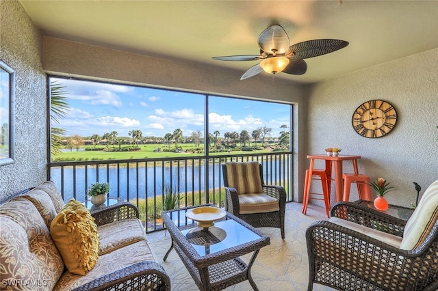 sunroom / solarium with a water view and ceiling fan