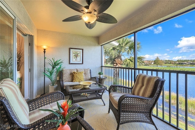 sunroom / solarium with ceiling fan and a water view