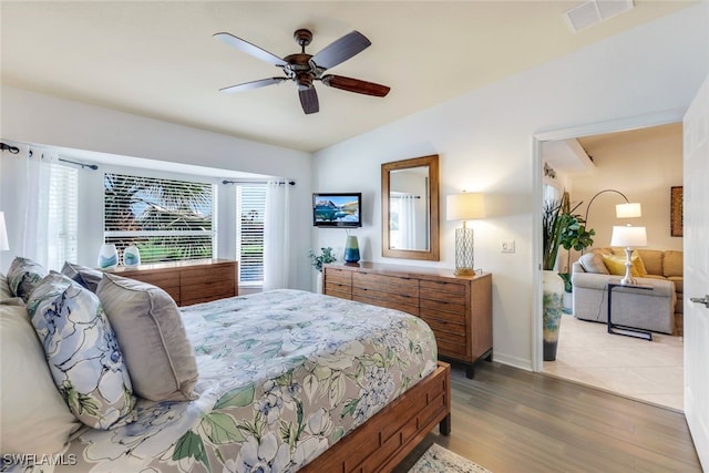 bedroom with ceiling fan, vaulted ceiling, and light hardwood / wood-style flooring