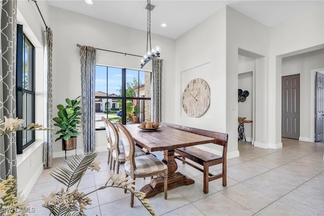 dining area with light tile patterned floors and a notable chandelier