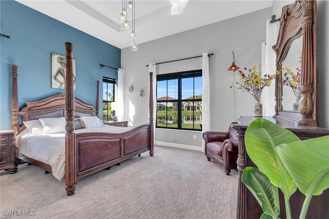 bedroom featuring light colored carpet and a tray ceiling