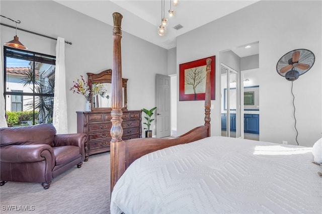 bedroom featuring light colored carpet and ensuite bath