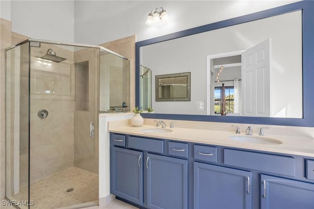 bathroom with a shower with shower door and vanity