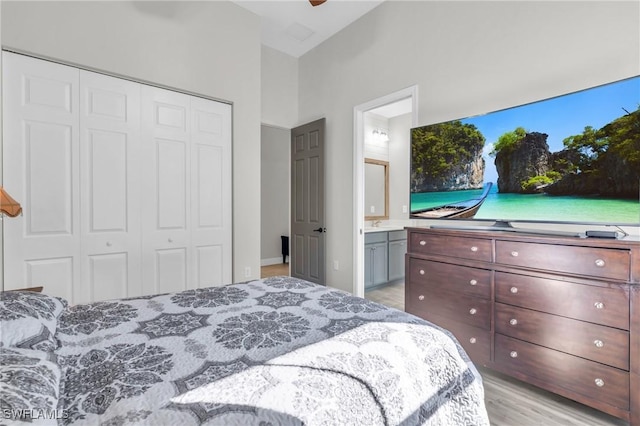 bedroom featuring light hardwood / wood-style floors, connected bathroom, a closet, and ceiling fan