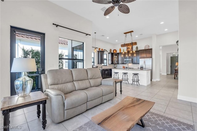 living room featuring ceiling fan, sink, and light tile patterned flooring