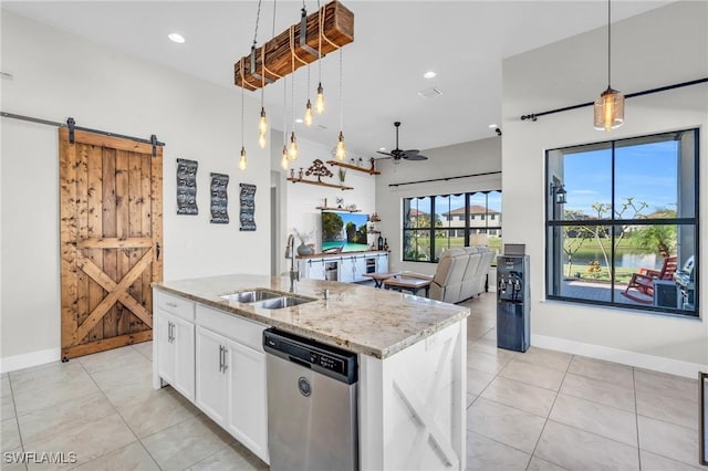 kitchen featuring dishwasher, white cabinetry, an island with sink, sink, and a barn door