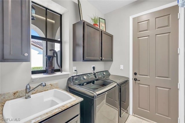 laundry area featuring washer and clothes dryer, sink, and cabinets