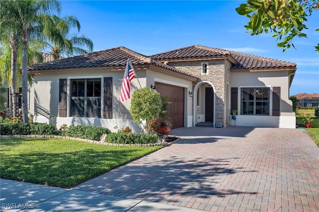 mediterranean / spanish home with a garage and a front lawn