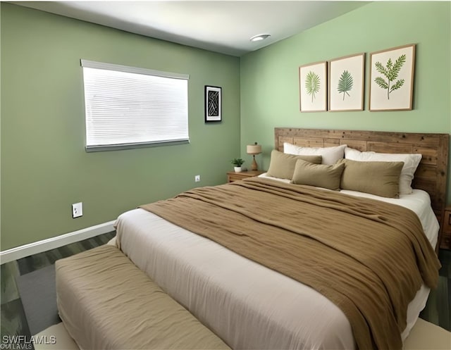 bedroom featuring baseboards and wood finished floors